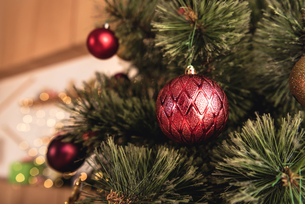 selective focus of christmas tree with red baubles in room - Fotografie, Obrázek