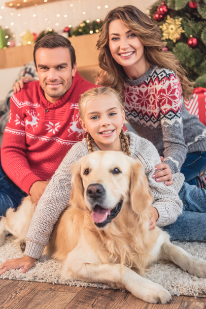 happy parents and daughter with golden retriever dog near christmas tree - Foto, imagen