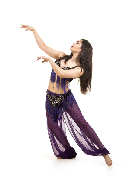 Attractive brunette girl with long hair dancing belly dance. on isolated white background. - Фото, изображение