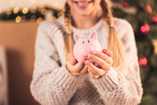 cropped view of female youngster holding pink piggy bank - Photo, Image
