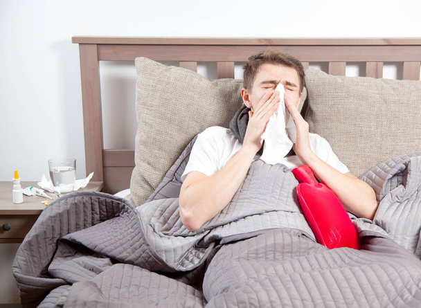 Man feeling bad lying in the bed and coughing - Photo, Image