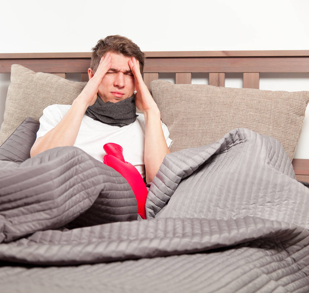 Homem sentindo-se mal deitado na cama e tosse
 - Foto, Imagem