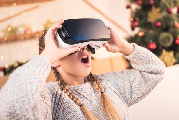 excited preteen child using virtual reality headset at christmastime - 写真・画像