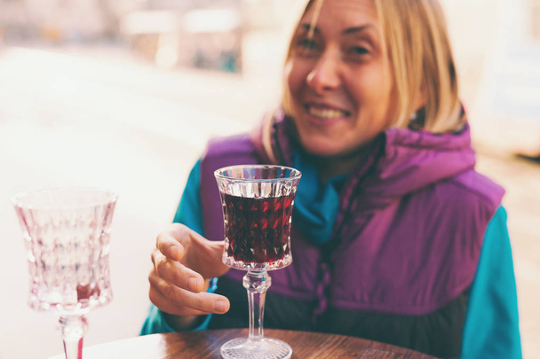 Femme tenant un verre de vin rouge. Du brandy de cerise. Une fille dégustant une boisson alcoolisée. Addiction à l'alcool
. - Photo, image