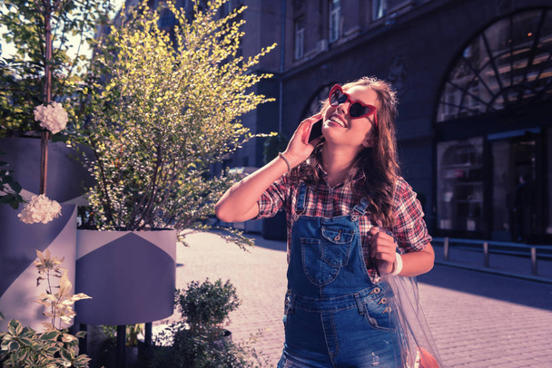 Happy woman wearing stylish casual clothes speaking by phone with her friend - Fotografie, Obrázek