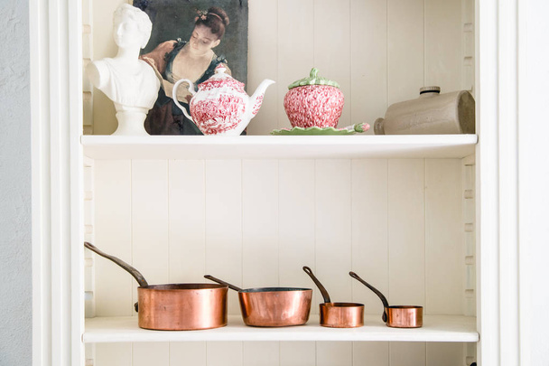 Cacerolas de cocina de cobre de pie en el mostrador
 - Foto, Imagen