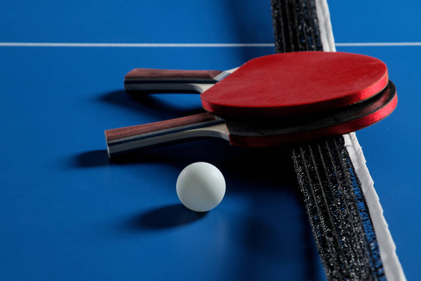 Ping pong. Accesorios para raqueta de tenis de mesa y pelota sobre una mesa de tenis azul. Deporte. Deporte juego
. - Foto, Imagen