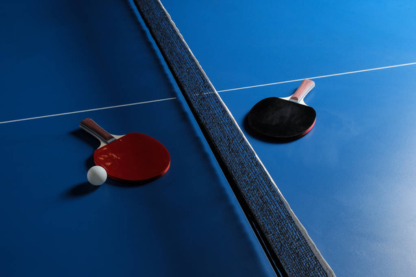 Пінг-понг. Аксесуари для настільного тенісу та м'яча на синьому тенісному столі. Спорт. Спортивна гра
. - Фото, зображення