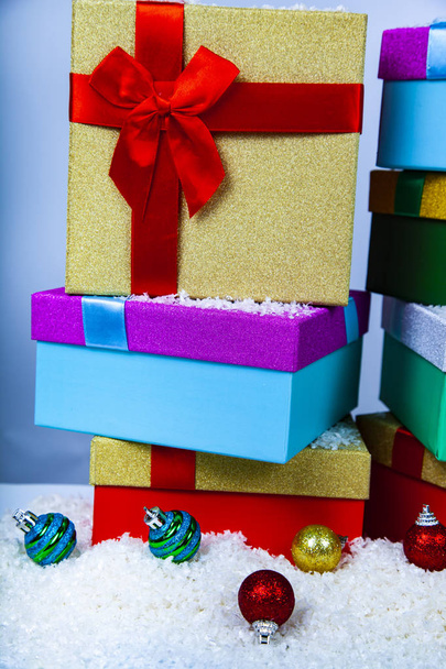 Яскраві різдвяні подарунки та кульки на снігу на синьому фоні. Декор на Новий рік або Різдво
 - Фото, зображення
