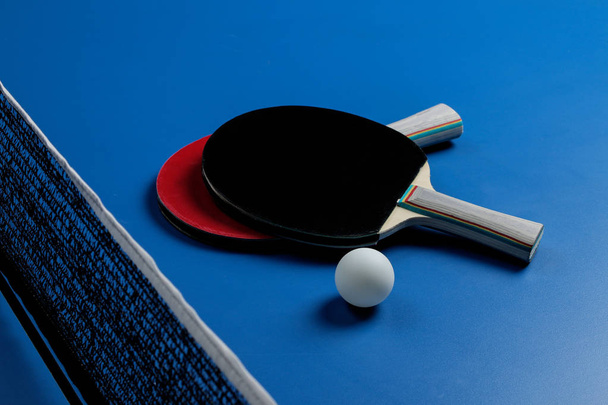 Ping pong. Příslušenství pro stolní tenis raketa a míček na modré tenisový stůl. Sport. Sportovní hra. - Fotografie, Obrázek
