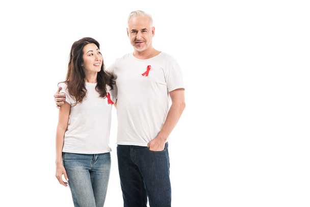 happy adult interracial couple in blank t-shirts with aids awareness red ribbons embracing isolated on white - Photo, Image