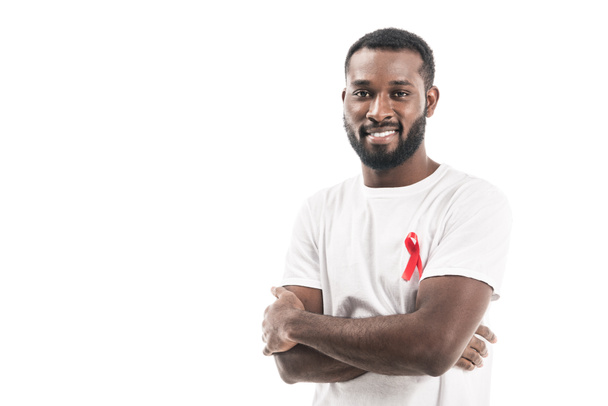 handsome african american man in blank white t-shirt with aids awareness red ribbon looking at camera isolated on white - Photo, Image