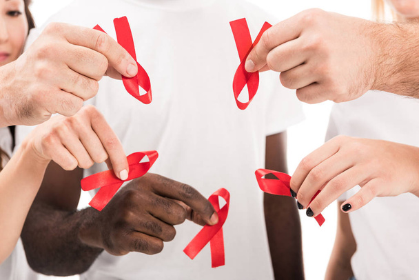 περικοπεί shot ομάδας ανθρώπων σε κενό λευκό t-shirts κρατώντας aids ευαισθητοποίησης κόκκινες κορδέλες - Φωτογραφία, εικόνα