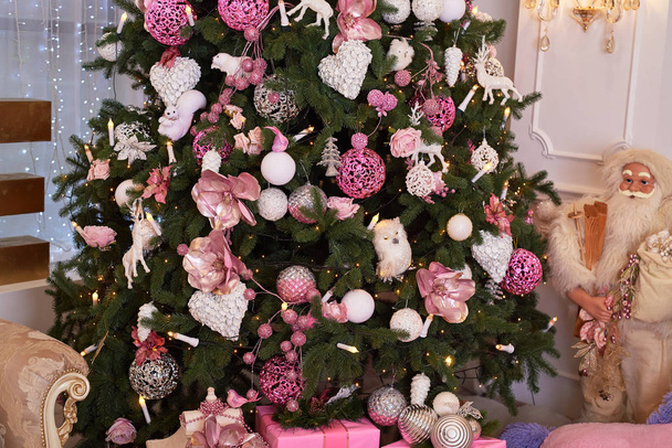 Closeup of Christmas tree decorated with white and pink baubles and garland, copy space. Christmas decorations. Holiday background. Christmas tree. Greeting card - Photo, image