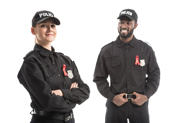 smiling police officers with aids awareness red ribbons isolated on white - Photo, Image