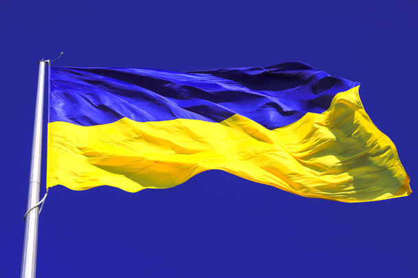 Флаг Украины. Самый большой желто-синий государственный флаг Украины на флагштоке 30 метров в украинском городе Днепр - Фото, изображение