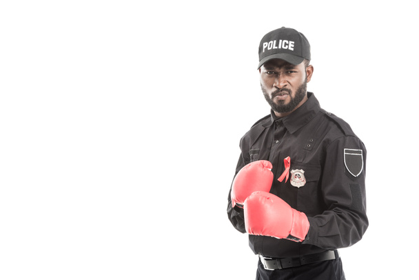 oficial de policía afroamericano serio con guantes de boxeo aislados en blanco, concepto de sida de lucha
 - Foto, Imagen