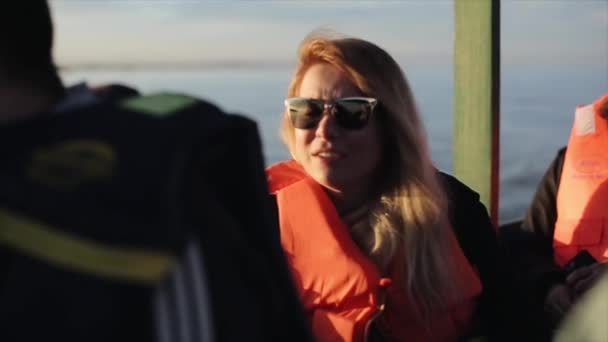Jonge vrouw in zonnebril is reizen op boot over zee in Afrika vroeg in de ochtend. Meisje genieten van het prachtige landschap og. Kaukasische vrouw land verkennen over water. - Video