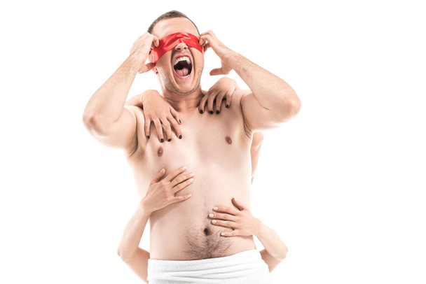 gritando hombre sin camisa con los ojos atados y las manos femeninas tocándolo por detrás aislado en blanco, concepto de sida
 - Foto, Imagen