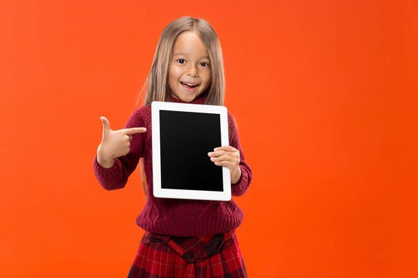 Little funny girl with tablet on studio background - Fotó, kép