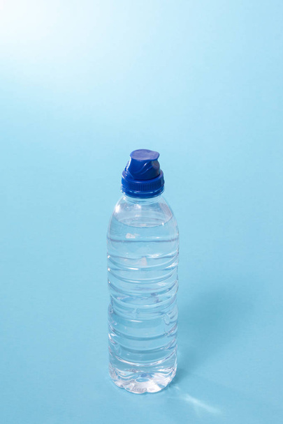 botella de agua de plástico sobre un fondo azul
. - Foto, imagen