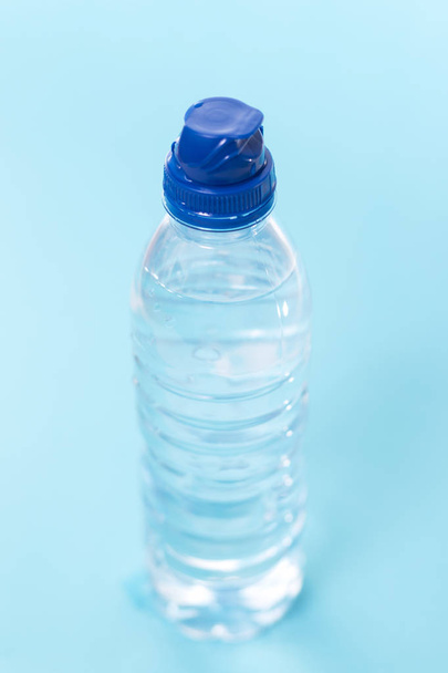 plastikowe butelki wody na niebieskim tle. - Zdjęcie, obraz