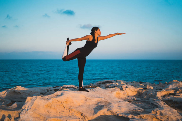 Retrato de linda jovem praticando ioga na praia
 - Foto, Imagem
