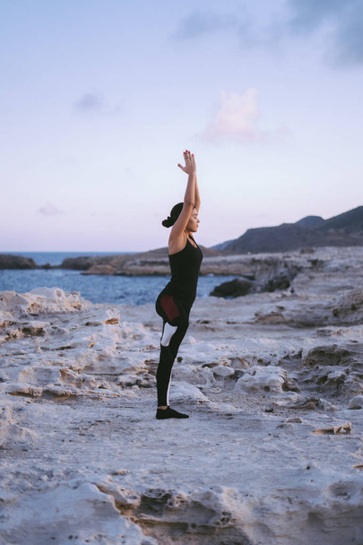 Portrait of gorgeous young woman practicing yoga on the beach - Fotó, kép