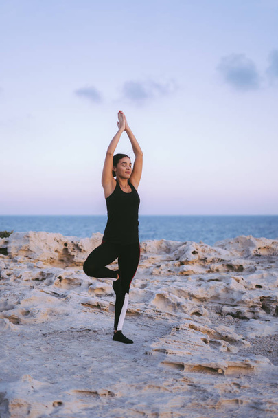 Portrait of gorgeous young woman practicing yoga on the beach - Fotó, kép
