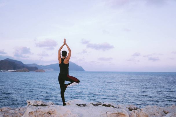 Retrato de linda jovem praticando ioga na praia
 - Foto, Imagem