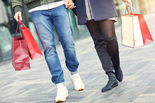 Piernas de pareja con bolsas de compras después de comprar en la ciudad
 - Foto, imagen