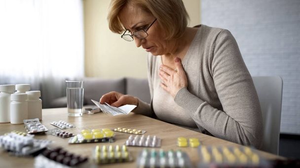 Senior lady feeling unwell, poor quality of medication dangerous self-medication - Фото, изображение