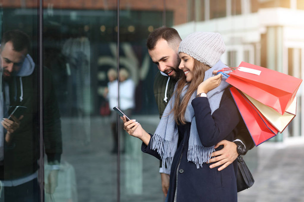 Portrét šťastného páru s nákupními taškami po nakupování ve městě - Fotografie, Obrázek