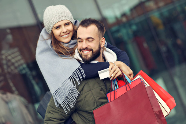 Portret szczęśliwej pary z torbami na zakupy po zakupach w mieście - Zdjęcie, obraz