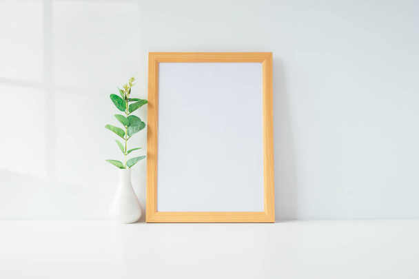Mock up portrait photo frame with green plant on table, home decoration. - Foto, Imagen