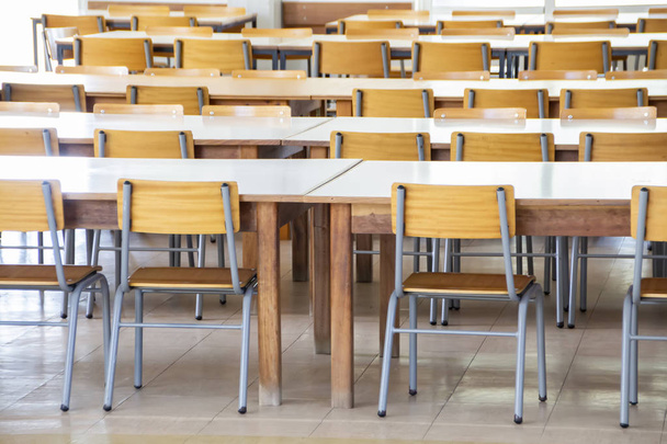 Vista interior de un comedor escolar vacío con mesas y sillas
. - Foto, Imagen