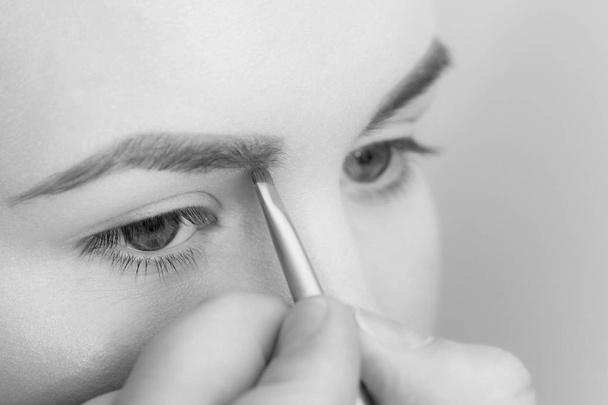 Girl getting brow color to eyebrows with brown brush - Photo, Image