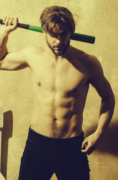 Athletic man with muscular torso standing with baseball bat - 写真・画像