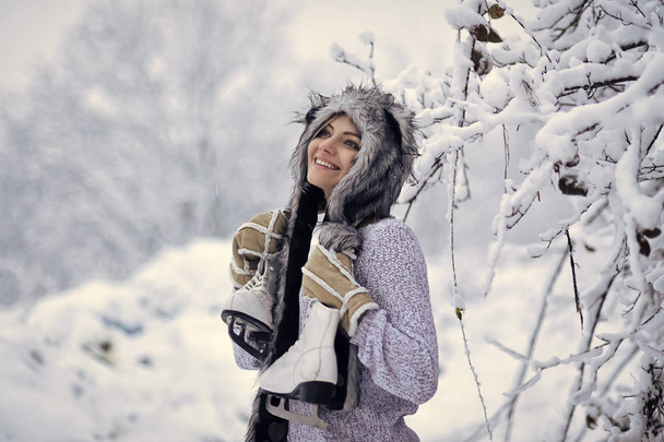 Happy girl smile with figure skates at trees in snow - Zdjęcie, obraz
