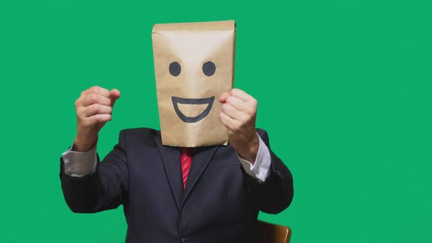 pojmu emoce, gesta. muž s papírové sáčky na hlavě, s malovanými emotikonu, úsměv, radost - Fotografie, Obrázek