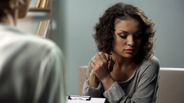 Triste femme parlant à son psychothérapeute lors d'une réunion personnelle, se sentant anxieuse
 - Photo, image