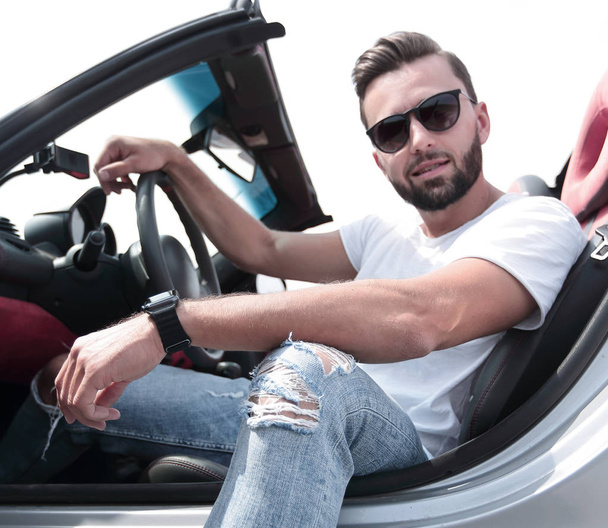 close up.stylish young man sitting in a luxury car - Foto, afbeelding