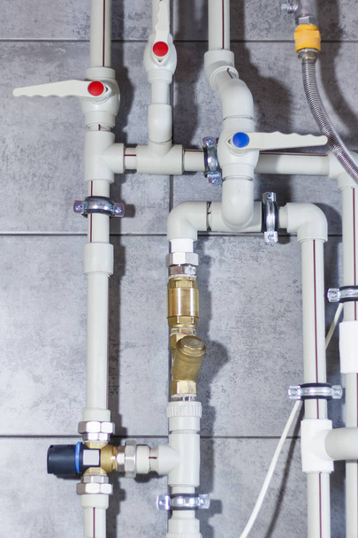 Sistema de aquecimento com tubos de plástico, válvulas e outros equipamentos na sala da caldeira
. - Foto, Imagem