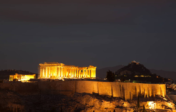 athens visto desde la colina Philopapou con vistas a Herodium, Acrópolis y el Partenón a la hora azul, Ática, Grecia
 - Foto, Imagen