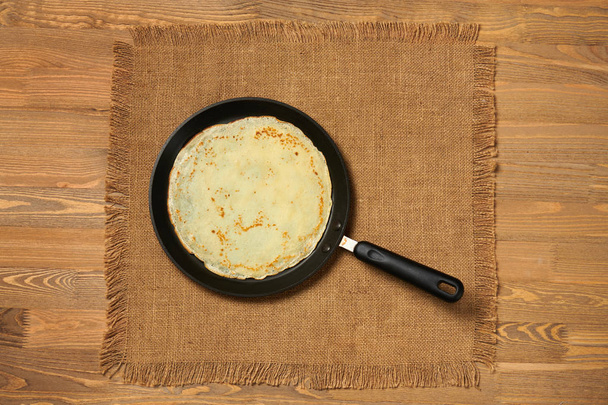 Κρέπα closeup, λεπτή τηγανίτα σε ένα τηγάνι, ξύλο παρασκήνιο - Φωτογραφία, εικόνα