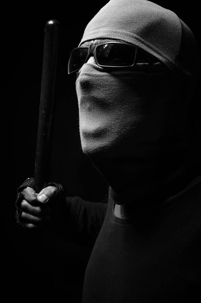 Uomo in maschera con un manganello della polizia
. - Foto, immagini