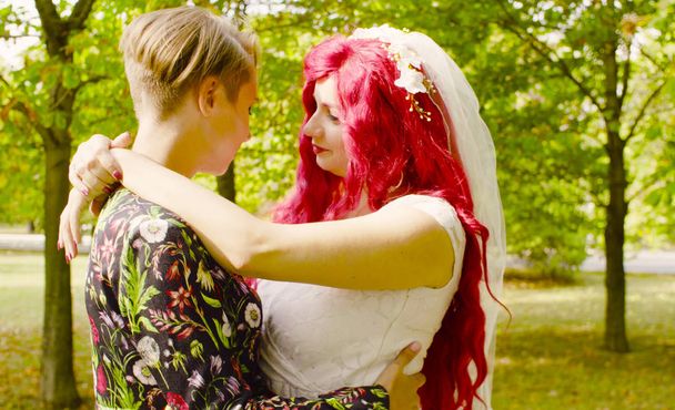 Lesbische bruiloft. De bruid en bruidegom zijn elkaar knuffelen en praten - Foto, afbeelding