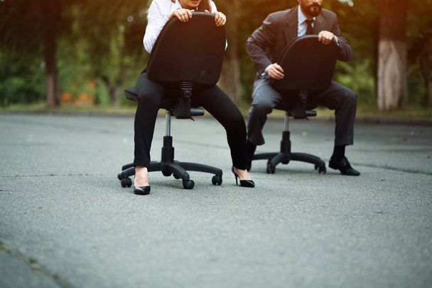 Businesspeople having racing on office chairs - Фото, зображення