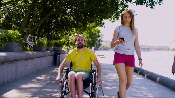 Young disable man on a walk near the river with his wife - Foto, imagen