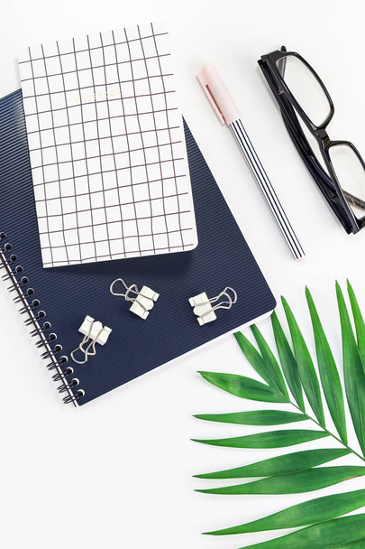 Top view flat lay office workspace desk styled design office supplies tropical palm leaves smartphone copy space black white background. Template office feminine blog social media - Photo, Image